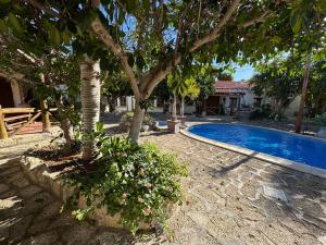 a swimming pool with a tree next to a house at Casa granero 2 in El Río