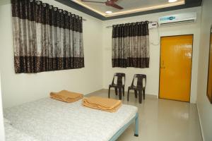 a room with two chairs and a table with towels on it at Swayam Beach Nivas in Srīvardhan