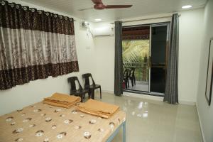 a room with a table and chairs and a window at Swayam Beach Nivas in Srīvardhan +4 photos