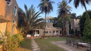 a house with palm trees in the yard at Seclude Hampi 1800 in Sandūr