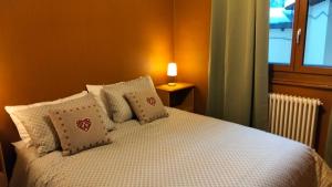 a bedroom with a bed with pillows and a window at La Cloche in Valtournenche