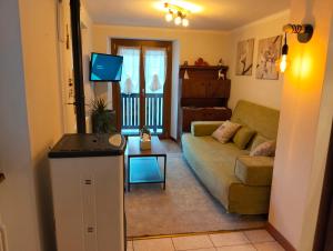 a living room with a couch and a tv at La Cloche in Valtournenche