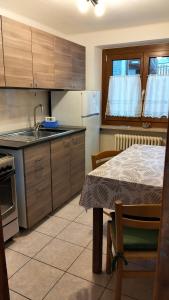 a kitchen with wooden cabinets and a table and a table and a sink at La Cloche in Valtournenche +12 photos
