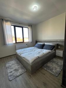 a bedroom with a large bed with two rugs at Tryavna Central Apartments-Harmony in Tryavna +1 photo