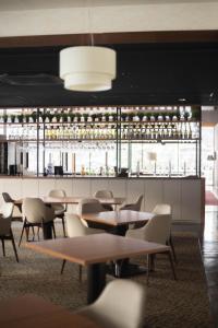 ein Restaurant mit Tischen und Stühlen und einer Bar in der Unterkunft Hotel Goryukan in Hakuba