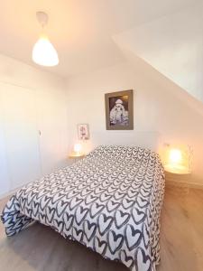 a bedroom with a bed with a black and white comforter at Apartamento Maruja Mallo in Viveiro +14 photos