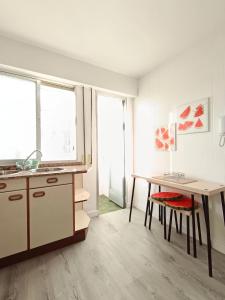 a kitchen with a desk and a table with a table at Apartamento Maruja Mallo in Viveiro