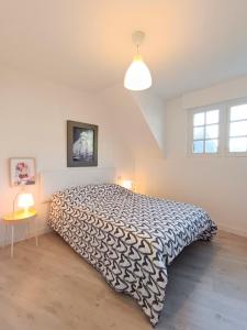 a bedroom with a bed with a black and white comforter at Apartamento Maruja Mallo in Viveiro