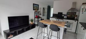 a kitchen with a table and two bar stools at La zen escapade in Ollioules