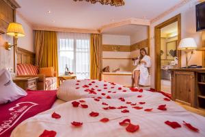 a woman in a hotel room with roses on a bed at ... mein romantisches Hotel Toalstock in Fiss