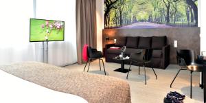 Uma TV ou centro de entretenimento em Central Park Hôtel & Spa