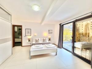 a white bedroom with a bed and a large window at Apartments Villa Stefan in Budva +117 photos