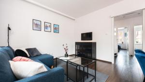 a living room with a blue couch and a table at Flatbook Comfort Old Town 8 in Gdańsk
