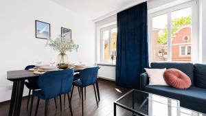 a living room with a table and a blue couch at Flatbook Comfort Old Town 8 in Gdańsk