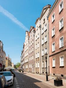 a city street with buildings and cars parked on the street at Flatbook Comfort Old Town 8 in Gdańsk