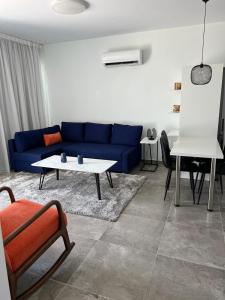 a living room with a blue couch and a table at Sea view Appartment in Larnaca