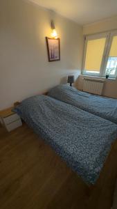 a bedroom with a bed with a blue comforter at Apartament 10 Słoneczna in Ełk +6 photos