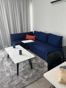 a living room with a blue couch and two tables at Sea view Appartment in Larnaca +29 photos