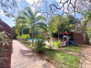 a backyard with a playground with a slide at Flamingo Holiday Flats in St Lucia