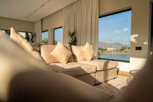 a living room with a couch and a large window at SS Resorts - Private Luxury Villa in Hatta