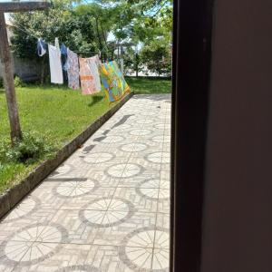 a walkway with clothes hanging on a clothes line at Suíte in Garopaba