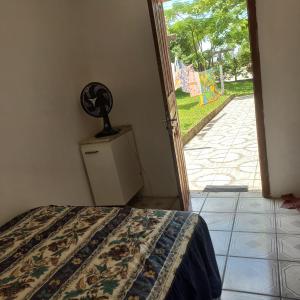 a bedroom with a bed and an open door at Suíte in Garopaba
