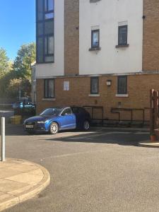 a blue car parked in front of a building at The Diickens Den - Stylish Rochester 1BR Flat - Sleeps 4 - Walk to High St, Castle & Station with Secured Parking - Contractor - Friendly and Ideal for Long Stays in Rochester