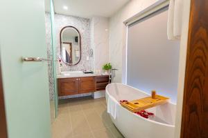 a bathroom with a tub and a sink and a mirror at B'Villa Luxury in Dong Hoi +26 photos