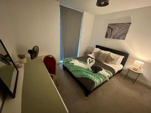 a bedroom with a bed with two swans on it at Apartment 3 in Birmingham