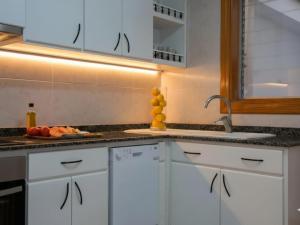 a kitchen with white cabinets and a sink at Harmony Seafront 365 by Can Ventet in Port de Pollensa +34 photos