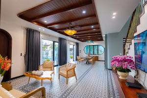 a living room with chairs and a table at B'Villa Luxury in Dong Hoi