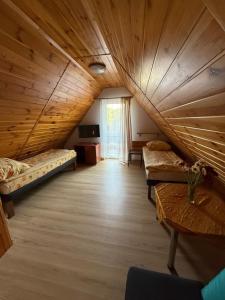 an attic room with two beds and a television at Kama Pobierowo in Pobierowo