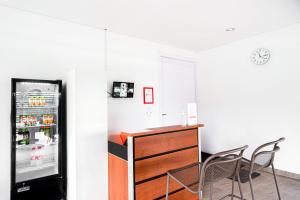 a kitchen with a refrigerator and two chairs at RedDoorz near Bukitsari Semarang in Jatingaleh