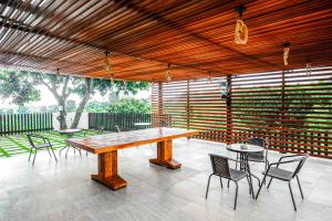 a patio with a wooden table and chairs at RedDoorz near Bukitsari Semarang in Jatingaleh