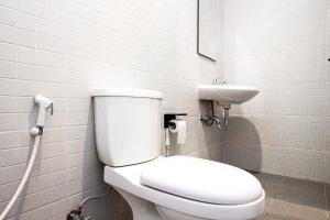 a bathroom with a white toilet and a sink at RedDoorz near Bukitsari Semarang in Jatingaleh +34 photos