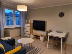 a living room with a couch and a table and a tv at Apartament 26 in Drawsko Pomorskie