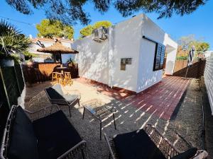 a patio with chairs and a table and an umbrella at Les cases del vent II in Calafat