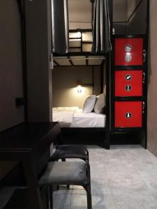 a bedroom with a desk and a bed with a red dresser at Thesleeperhomestay in Ban Chuk Kum