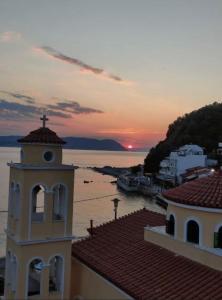 a building with a cross on top of it next to the water at SEA HOME Accommodation in Loutraki +14 photos