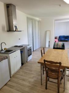a kitchen and dining room with a wooden table at Lieu charmant in Gimeux