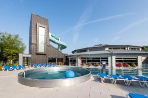 Ein Pool in einem Ferienresort mit Liegestühlen und einer Rutsche in der Unterkunft Péitche Lauer in Useldange
