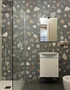 a bathroom with a shower with a sink and a mirror at Boca Luxury Rooms in Tarquinia +39 photos