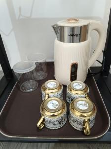 a tray with a coffee pot and a group of clocks at MEWAH guest house in Karangploso