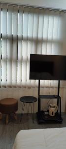 a bedroom with a bed and a tv and a table at MEWAH guest house in Karangploso