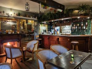 a bar with a table and chairs in a restaurant at Littledean House Hotel in Cinderford