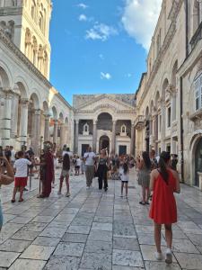 a group of people walking around a building at Delux Apartments Vele in Split