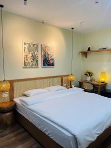 a large bed in a bedroom with two pictures on the wall at Silk Homestay LVC Central in Hanoi
