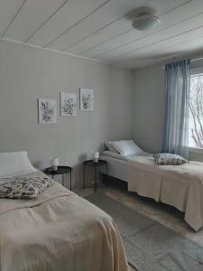 a white room with two beds and a window at Björktorpet och Soltorpet in Lepplax