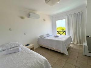 a bedroom with two beds and a window at Breeze Hotel in Natal +36 photos