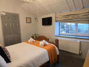 a bedroom with two beds and a window at Littledean House Hotel in Cinderford